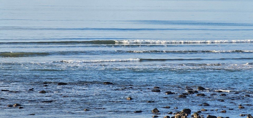 tiny wave breaking in the shallows with absolutely no wind